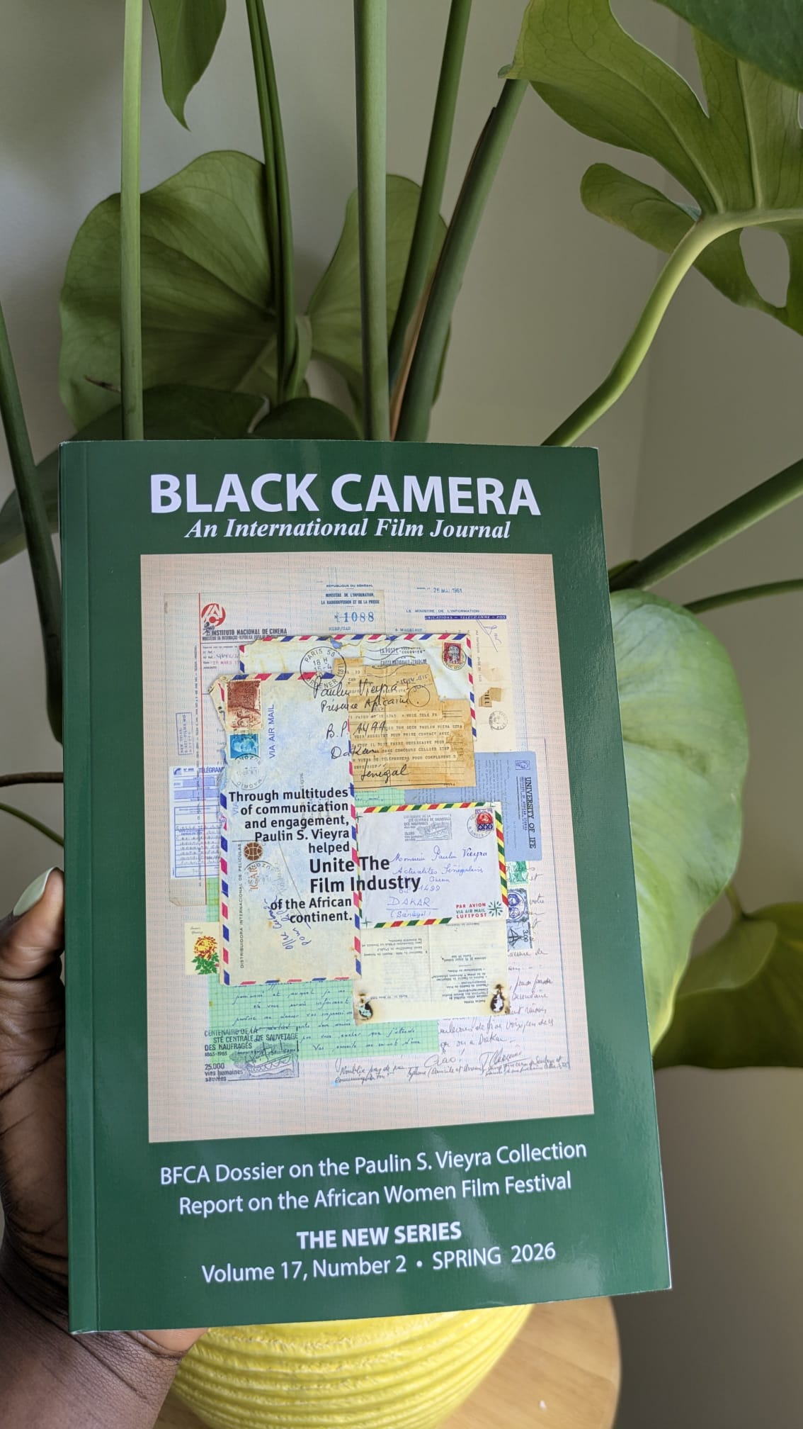 Hand holding the black camera publication